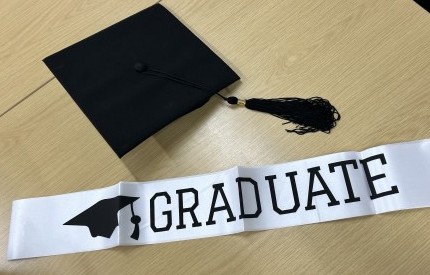 Picture shows a graduation hat and sash